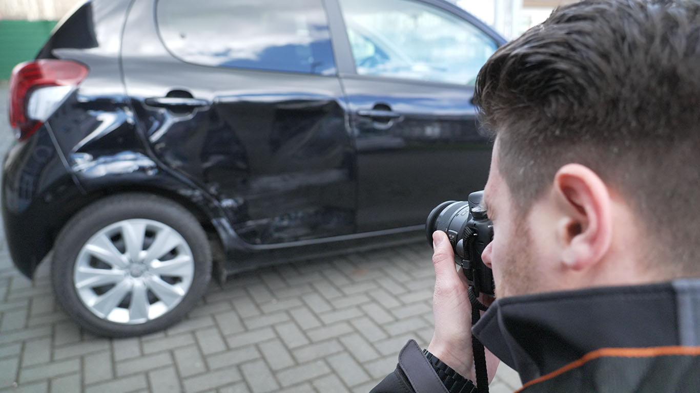Kfz Gutachter Christoph Jansen fotografiert Unfallschaden